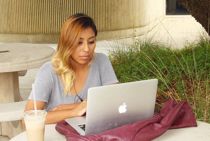 Woman sitting at a laptop outside