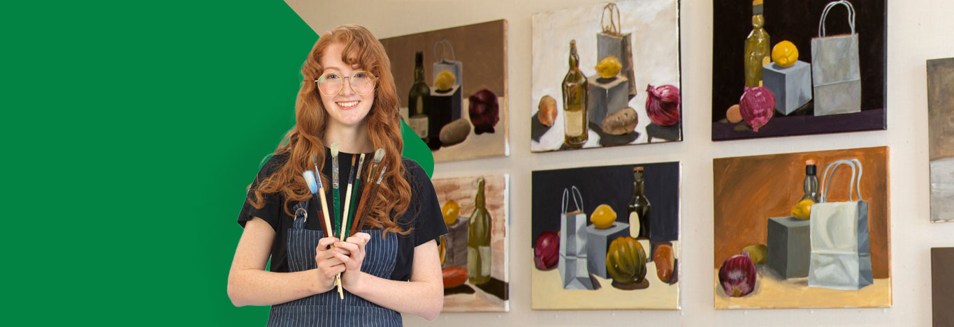 Student holding paintbrushes