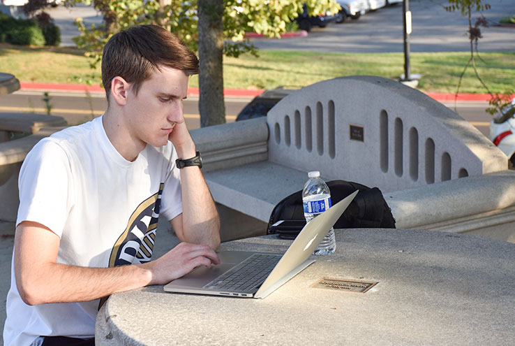Student outside on a laptop