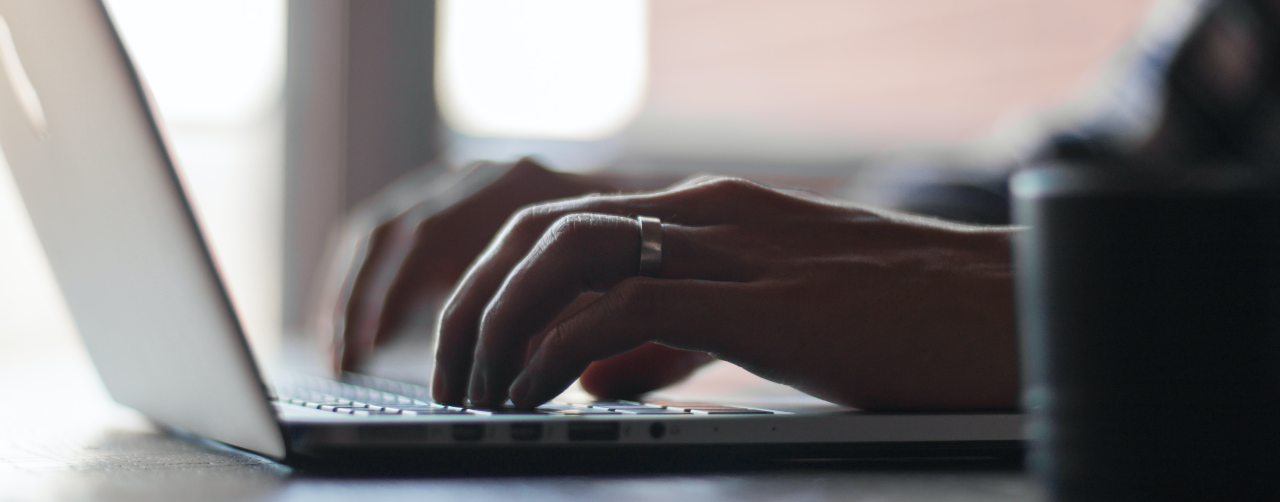 Hands typing on a laptop keyboard