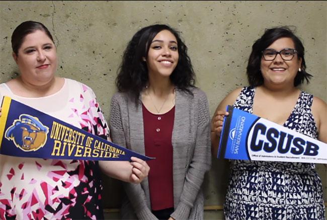 Three girls holding school pennants