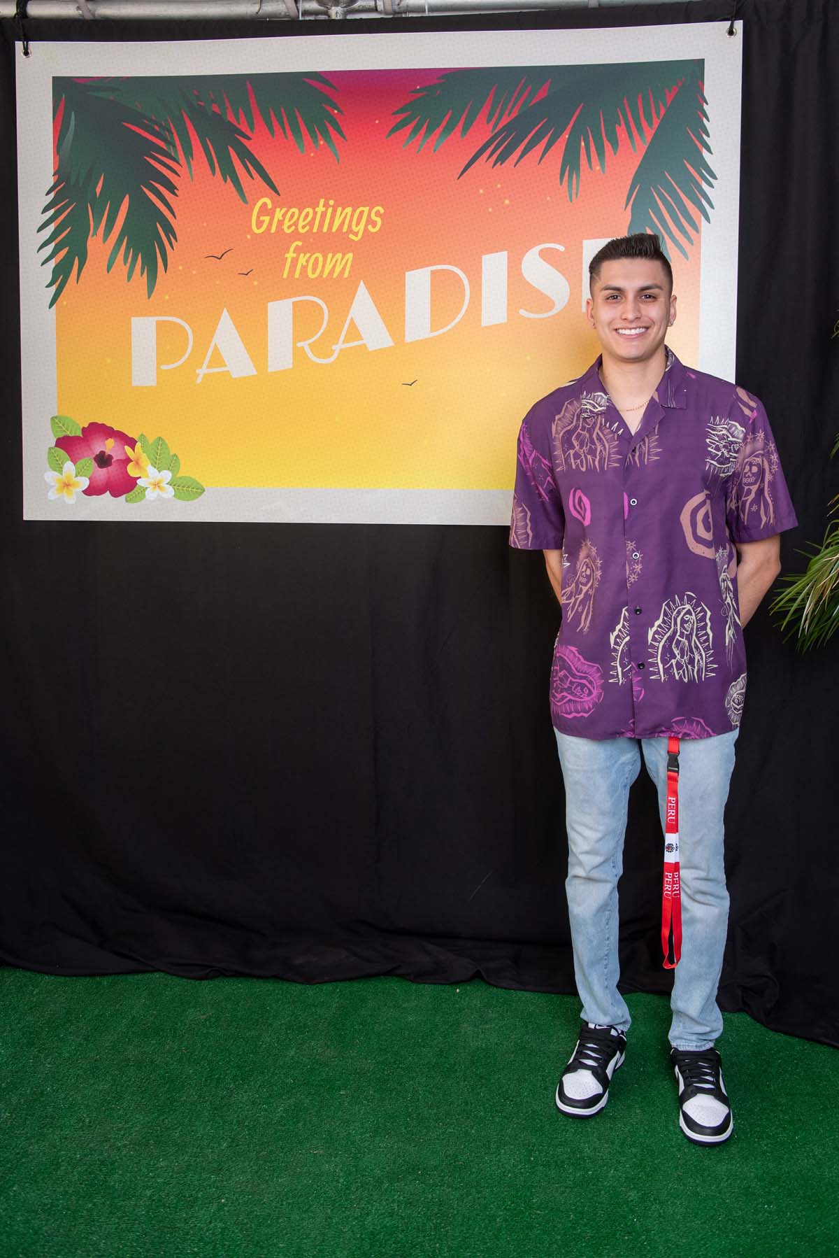 Person in front of Greetings from Paradise sign