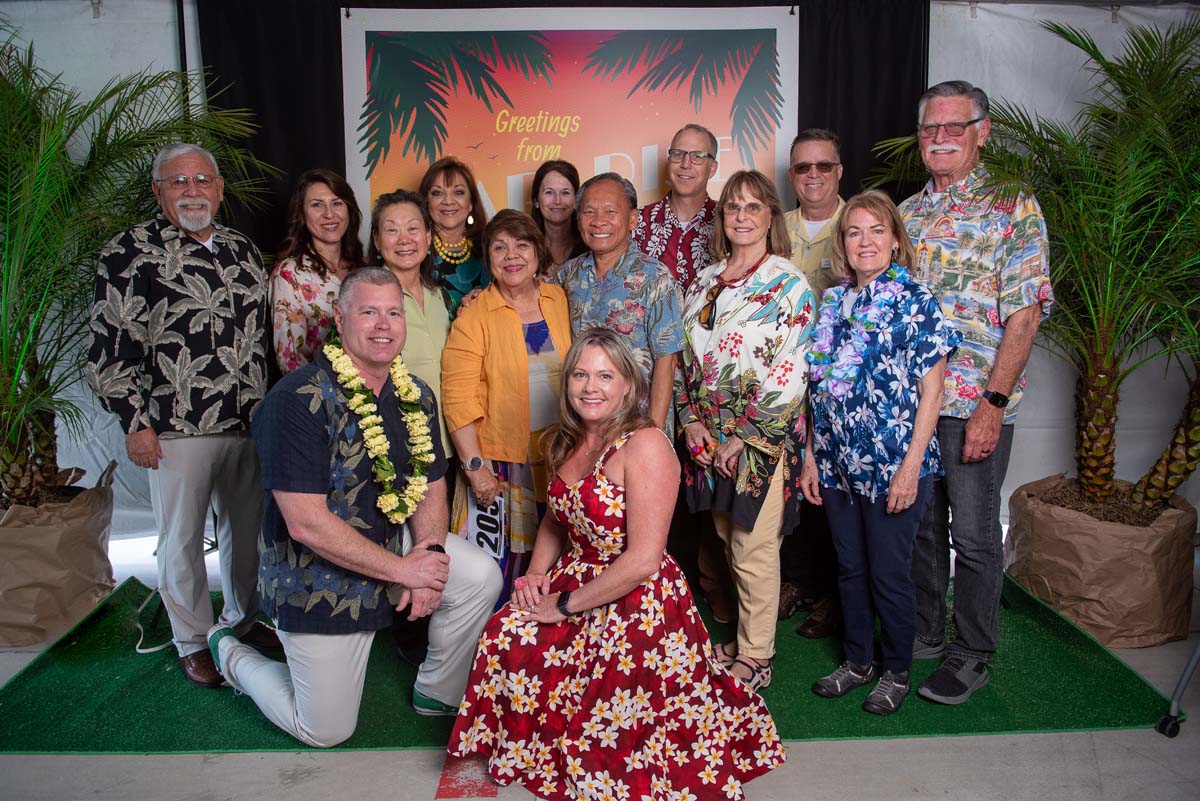 Group of people in front of Greetings from Paradise sign