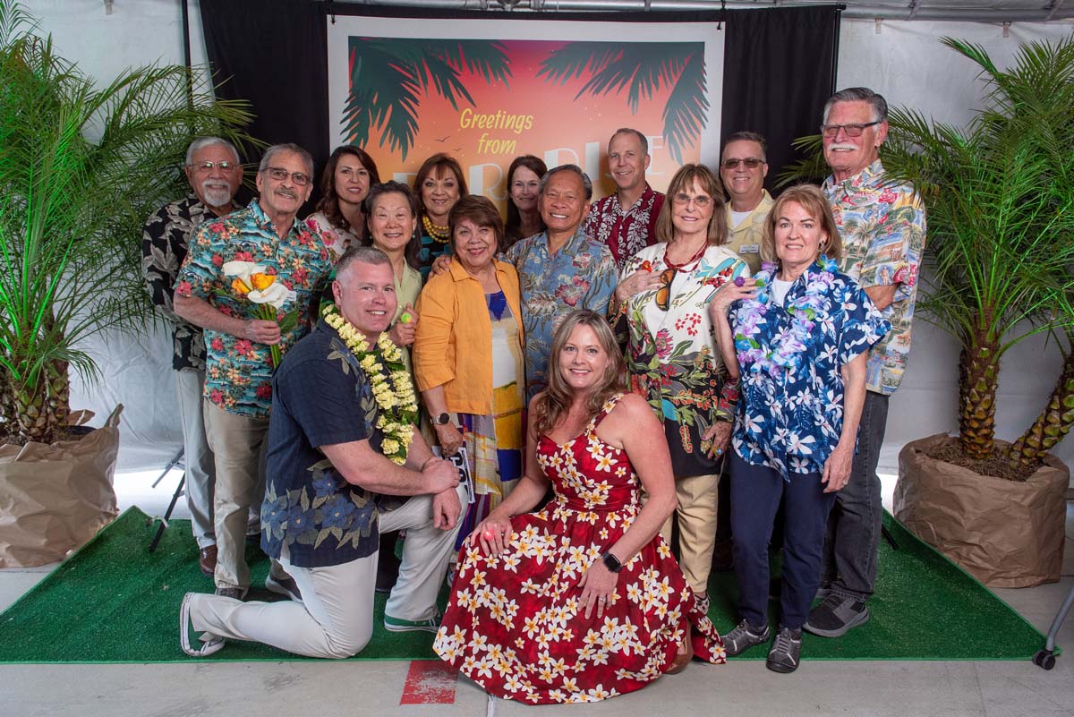 Group of people in front of Greetings from Paradise sign
