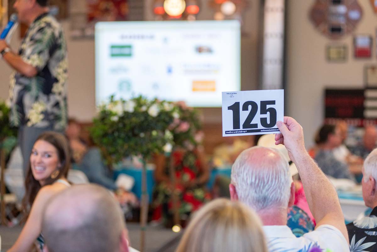 Person holding up bidding number