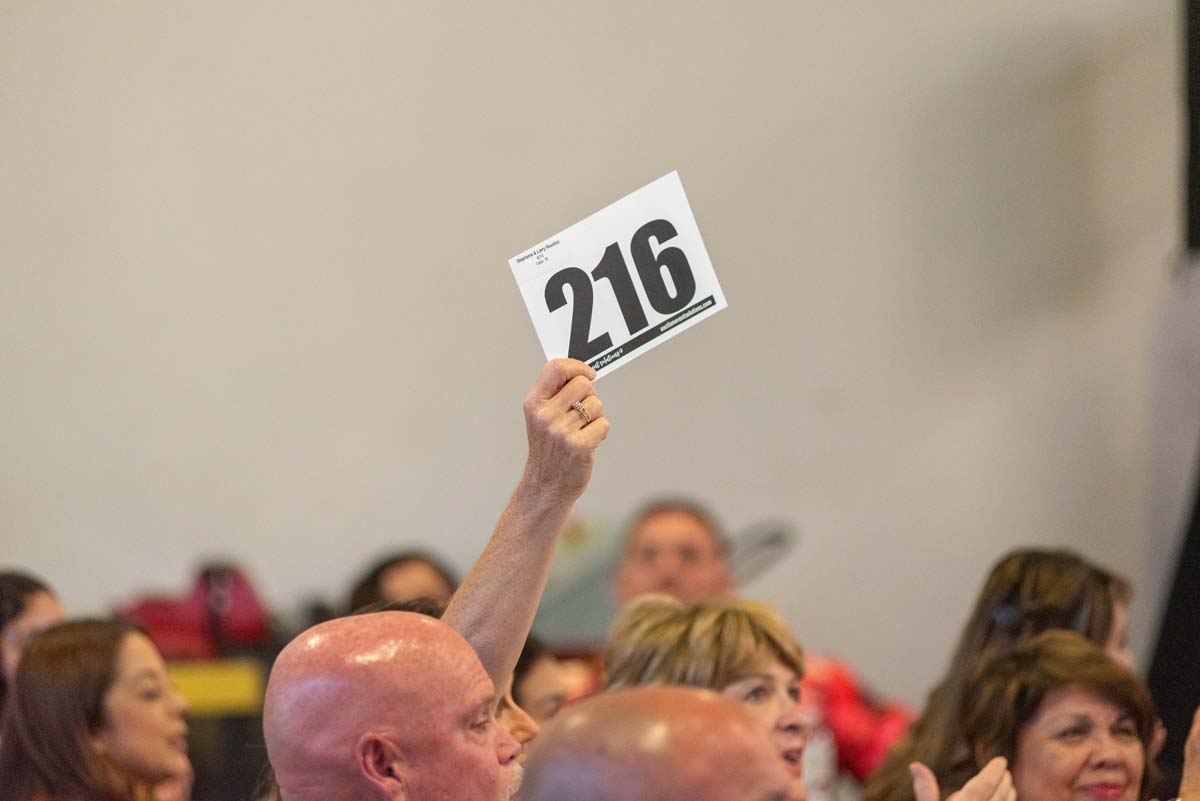 Person holding up bidding number