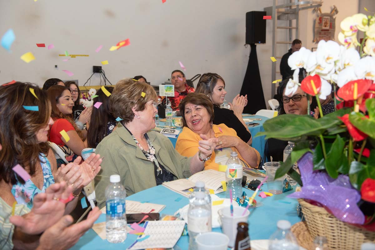 People at tables with confetti falling
