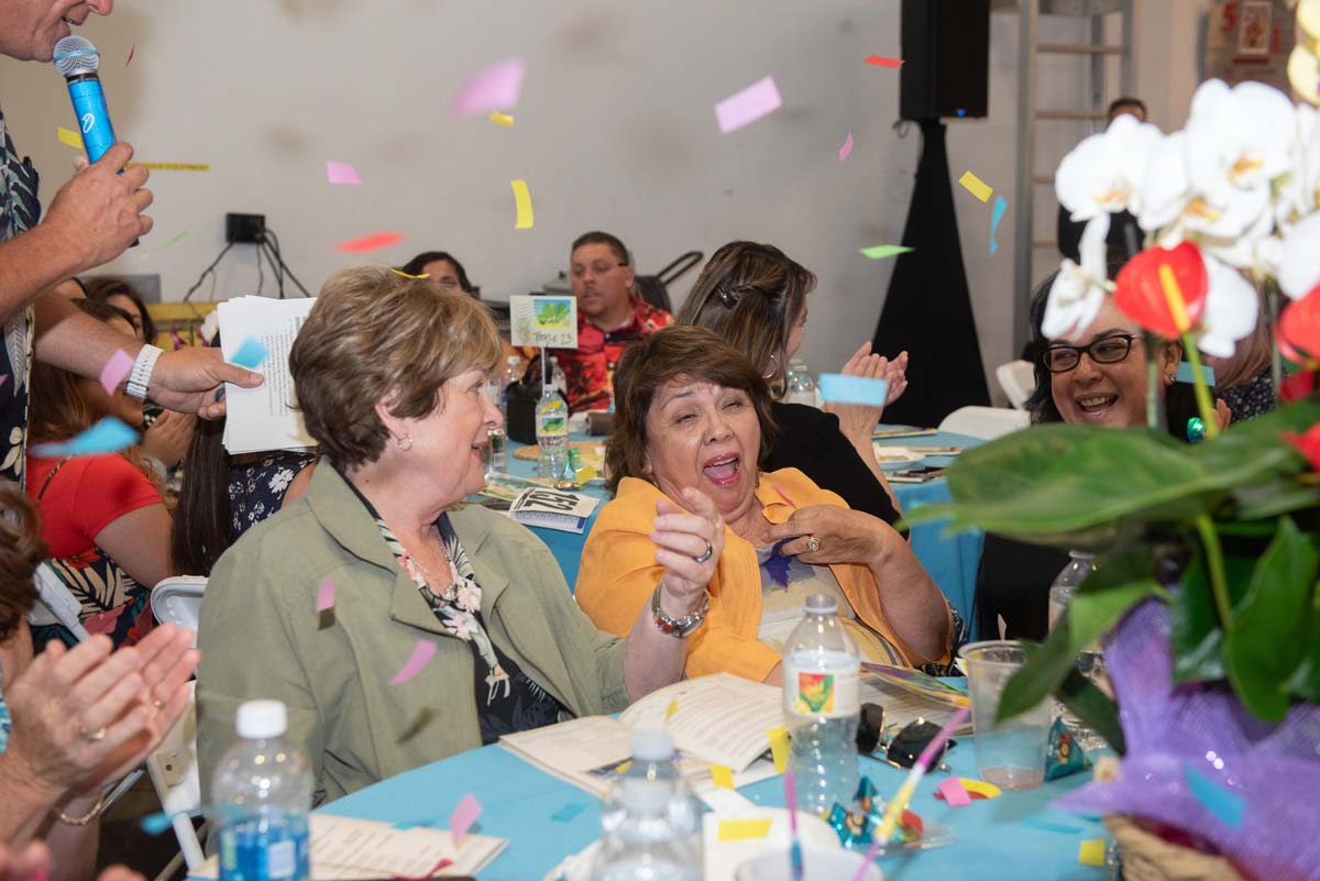 People at tables with confetti falling