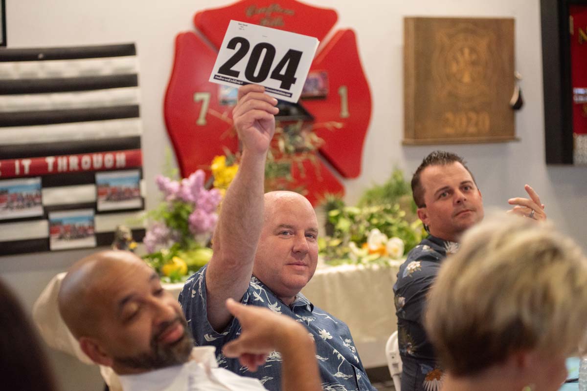 Person holding up bidding number