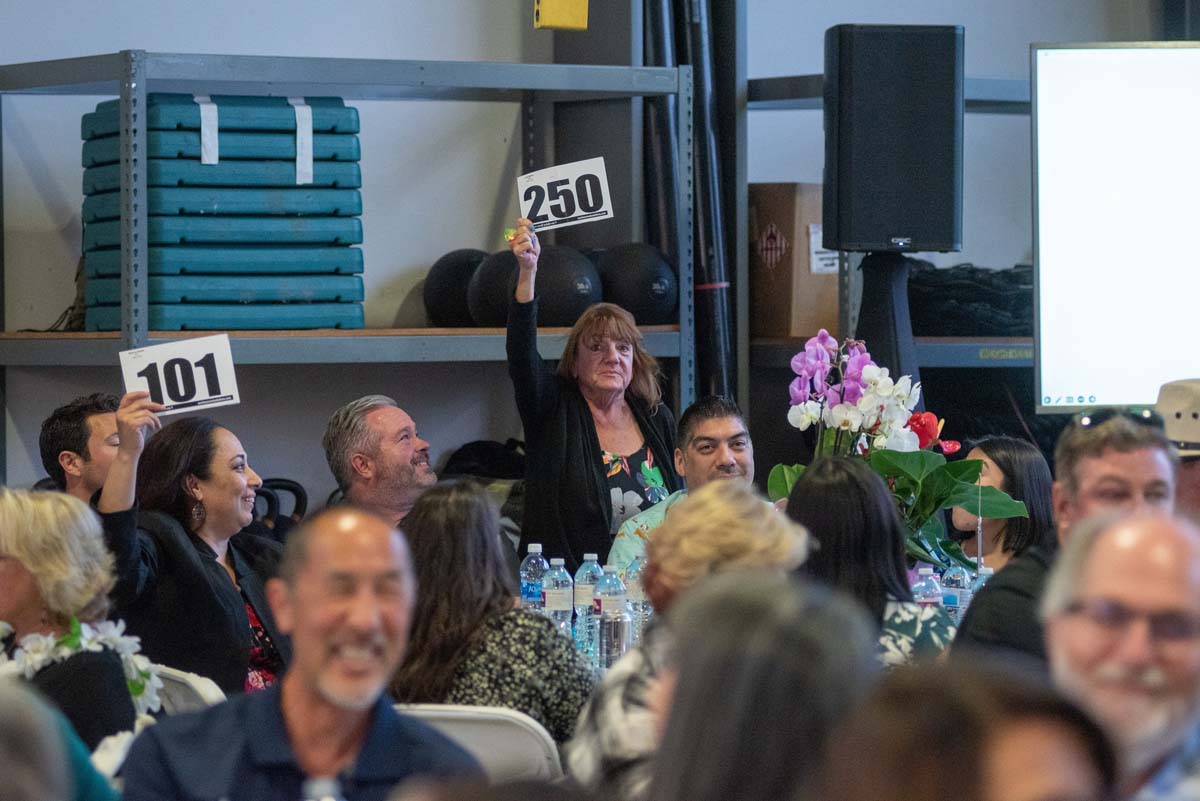 People holding up bidding numbers