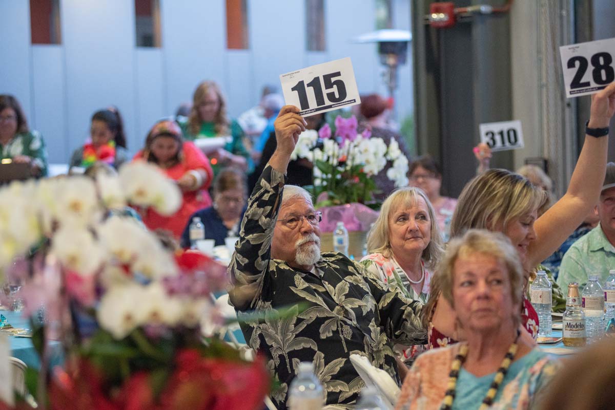 People holding up bidding numbers