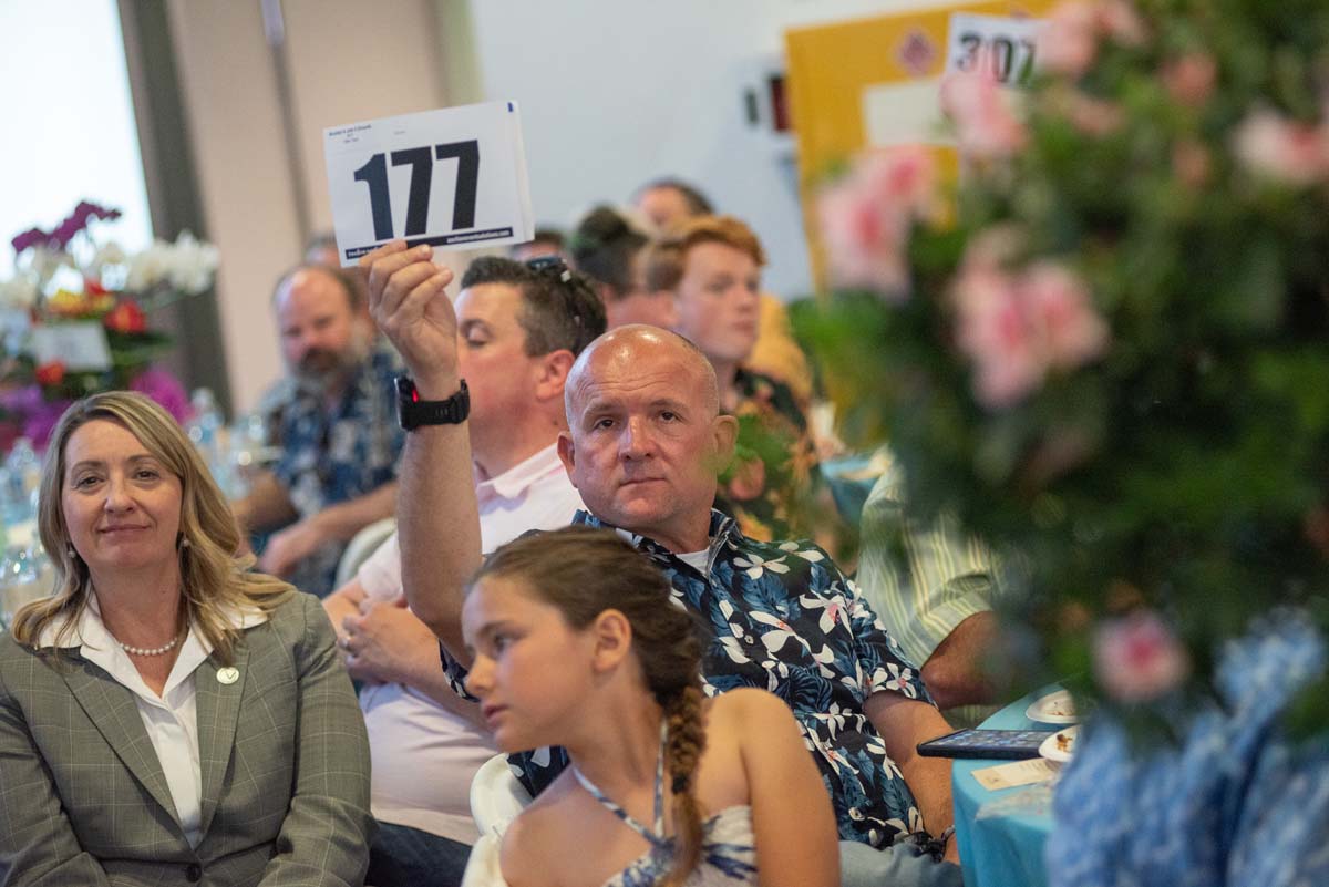 People holding up bidding numbers