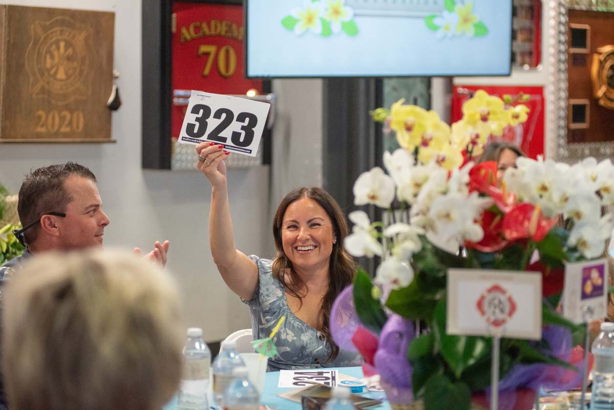 Woman holding up bidding numbers