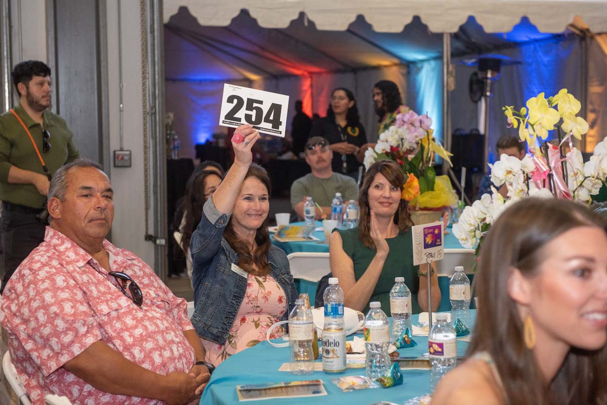 Person holding up bidding number