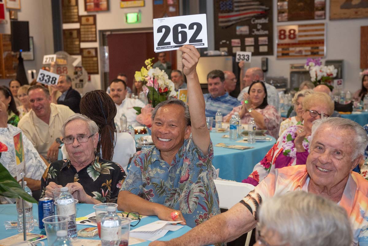 People holding up bidding numbers