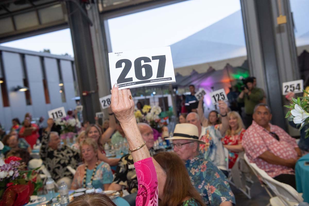 People holding up bidding numbers