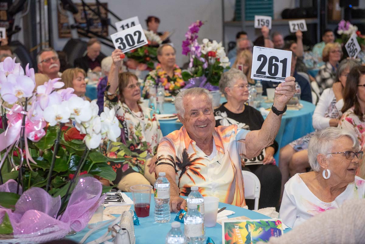 People holding up bidding numbers