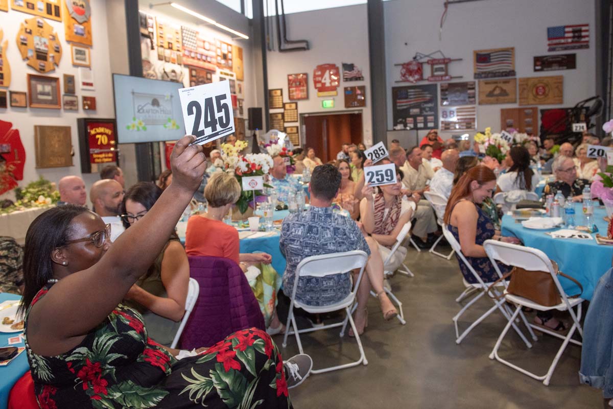 People holding up bidding numbers