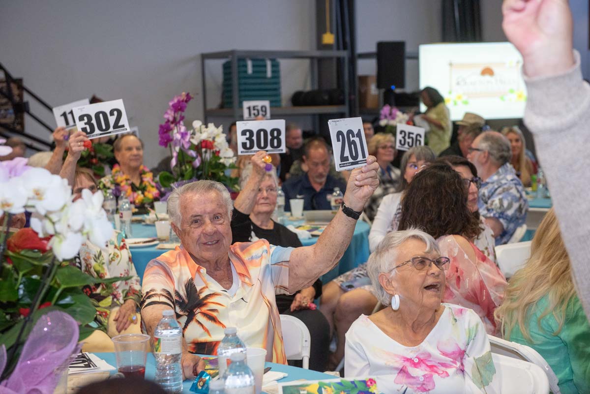 People holding up bidding numbers
