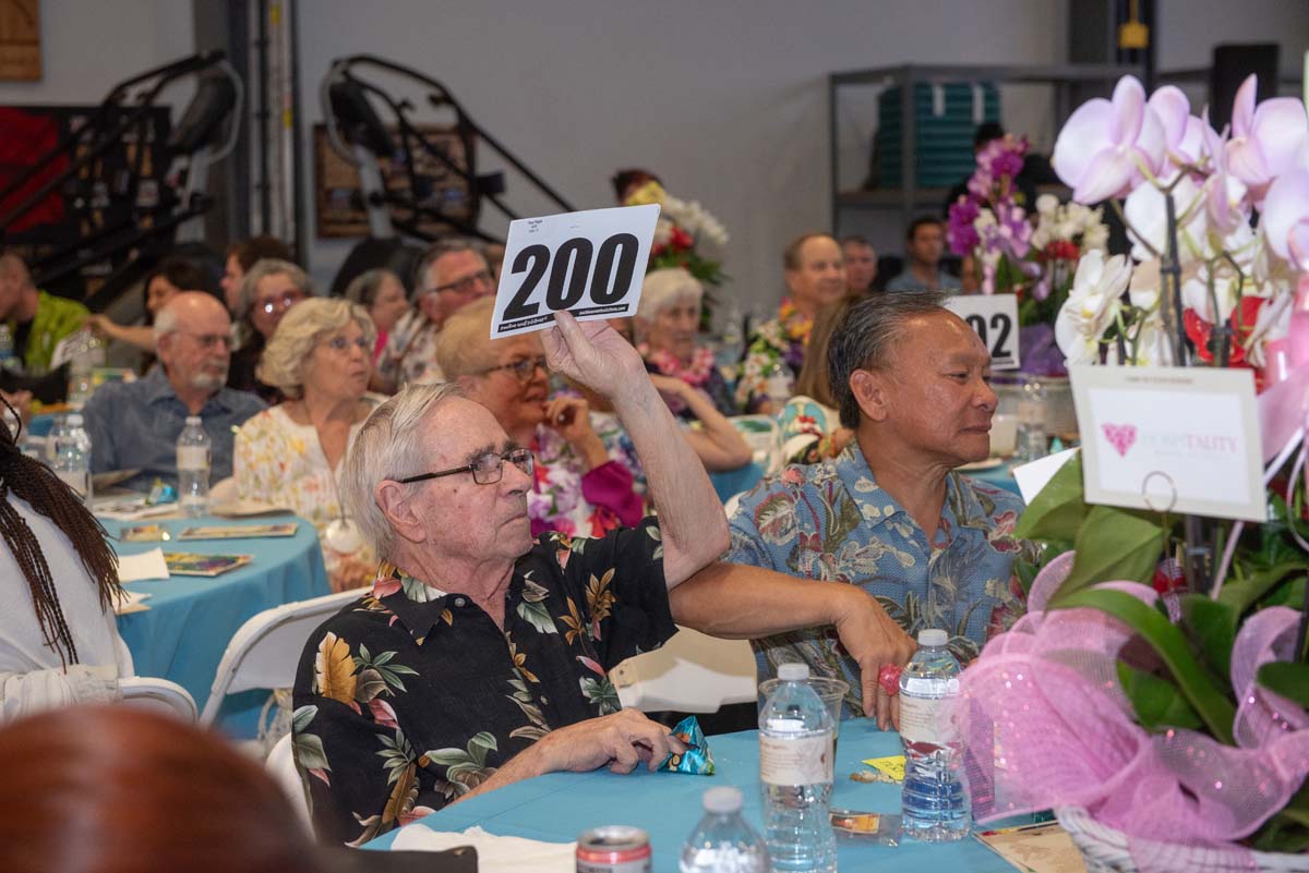 People holding up bidding numbers