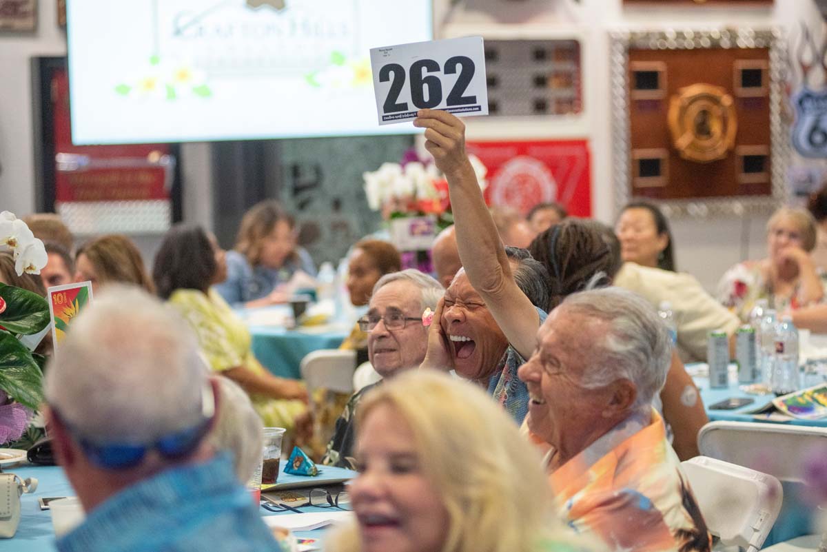 Person holding up bidding numbers