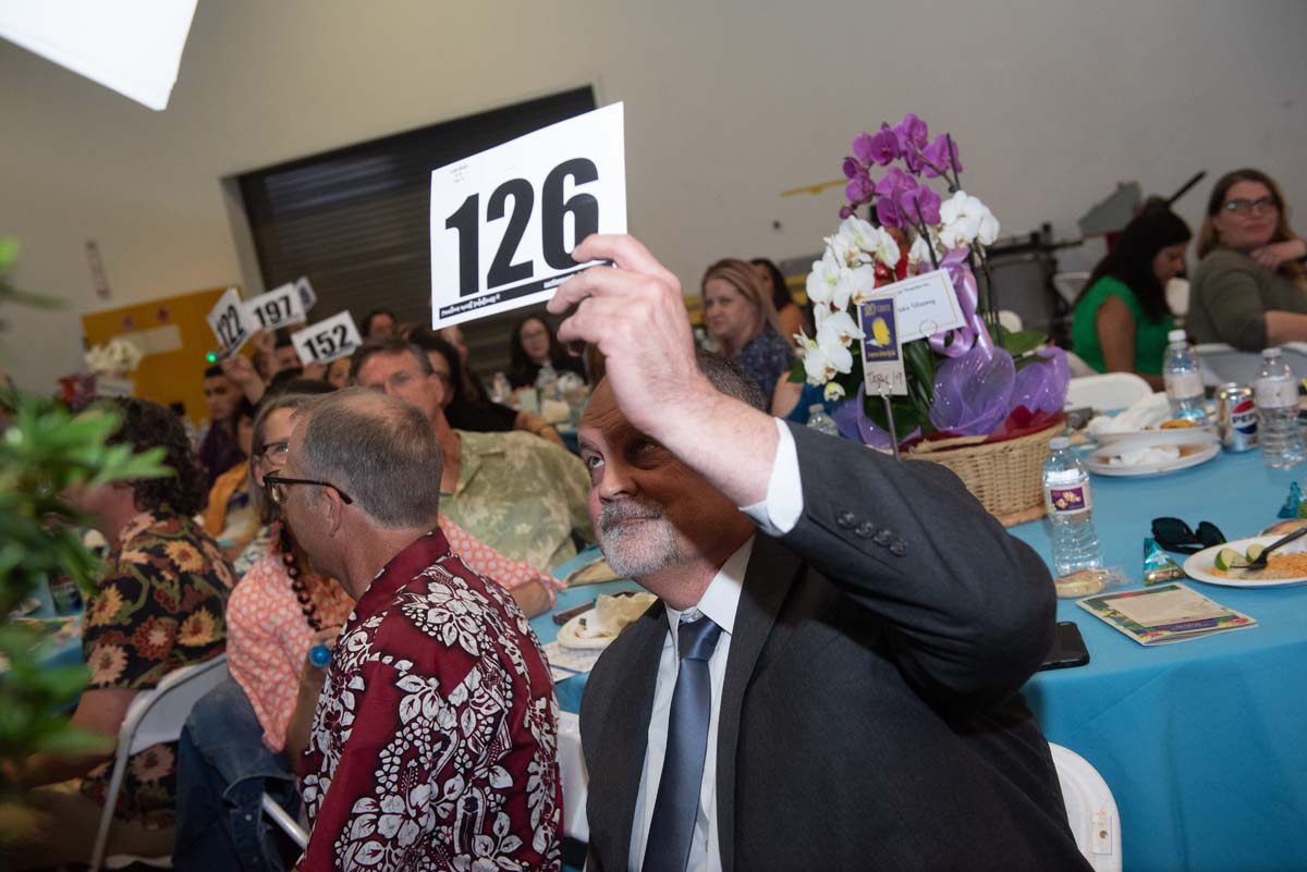People holding up bidding numbers