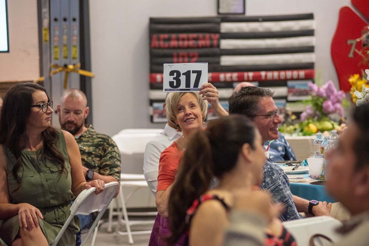 Person holding up bidding numbers