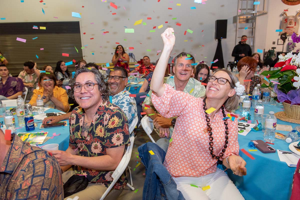 People seated at tables with falling confetti