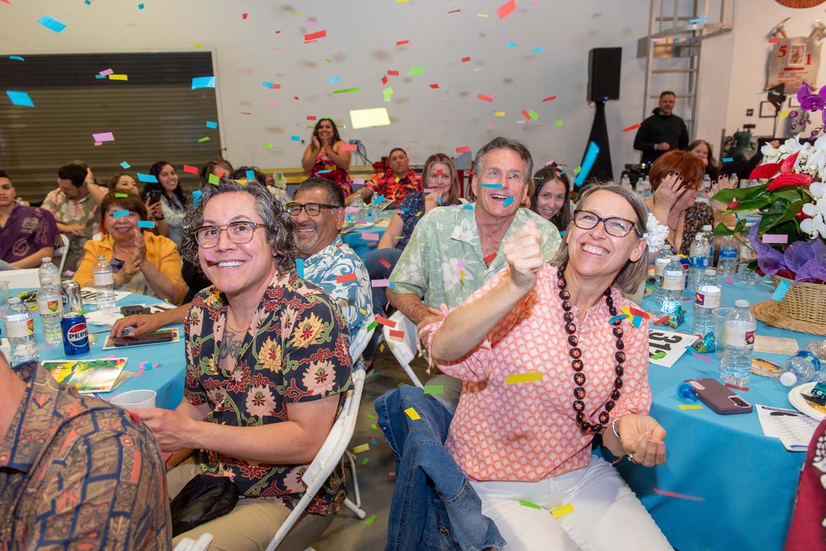 People seated at tables with falling confetti