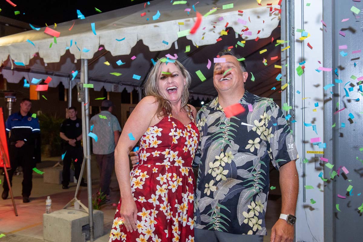 Two people next to awning with falling confetti