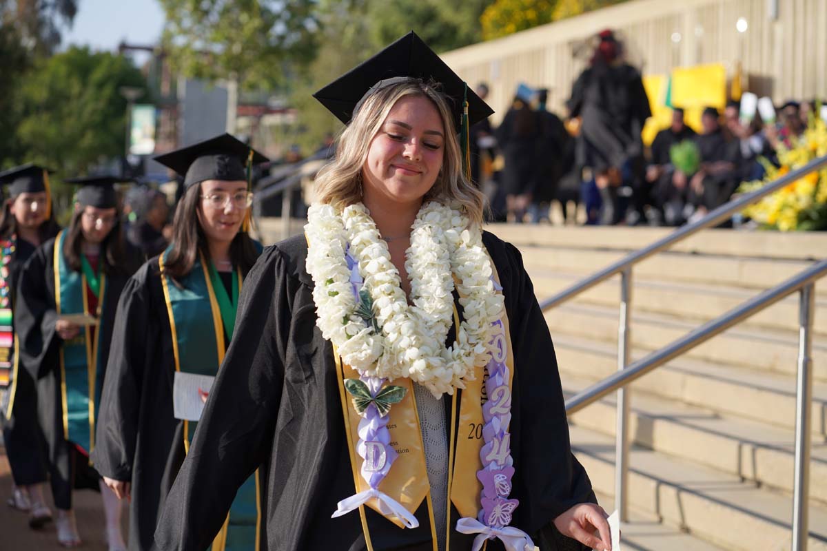 Graduates walk to stage at CHC's Commencement 2024.