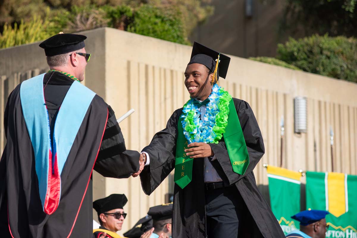 Graduates walk across stage at CHC Commencement 2024.