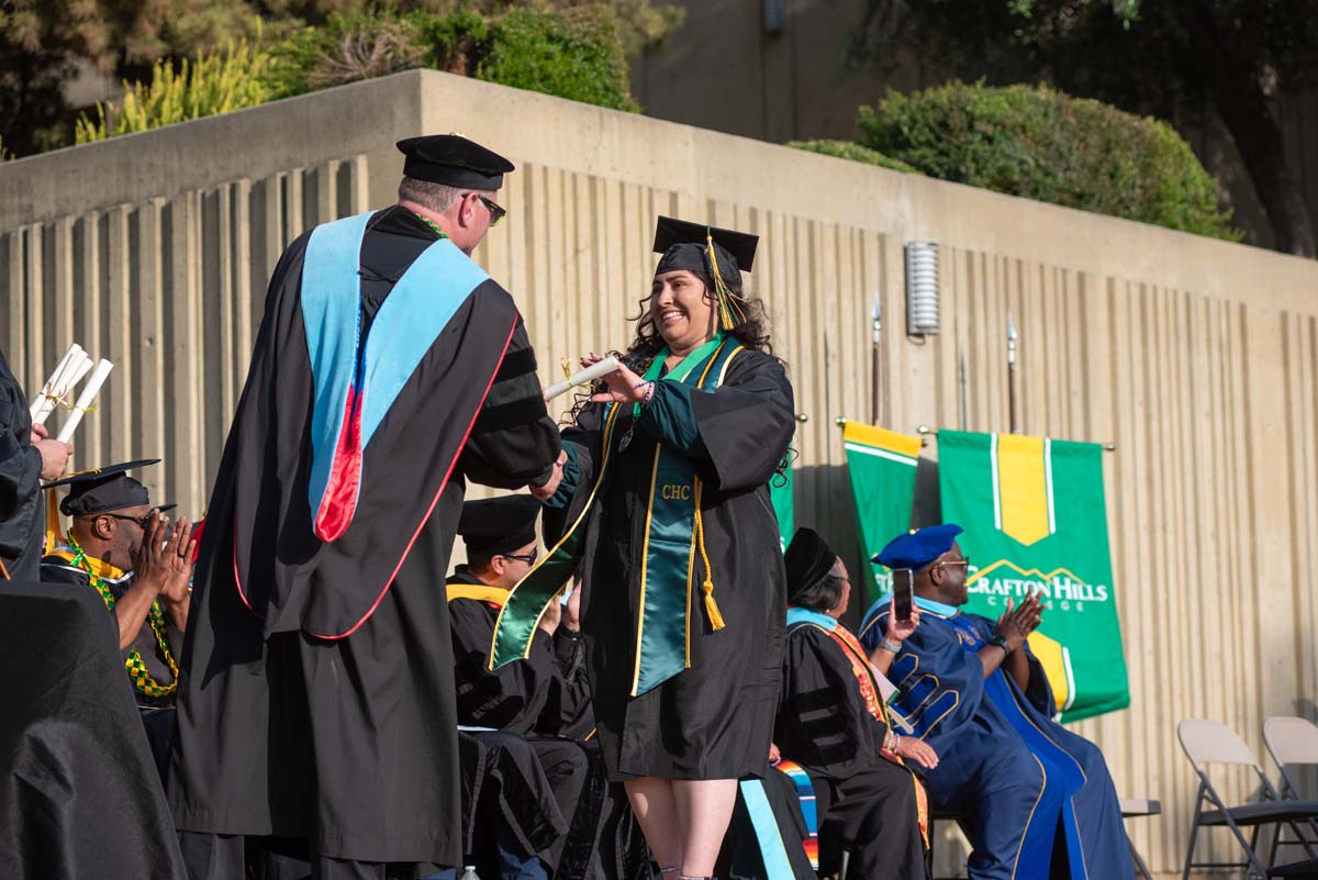 Graduates walk across stage at CHC Commencement 2024.