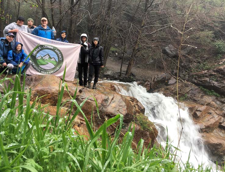 Hikers holding the Three Peaks banner