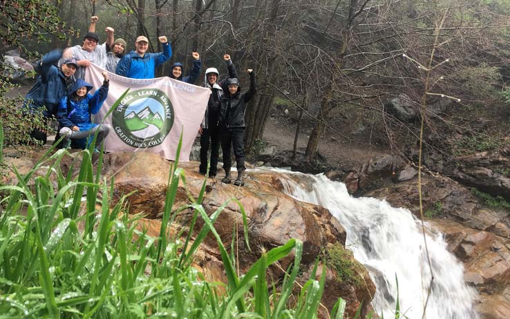 Hikers holding the Three Peaks banner