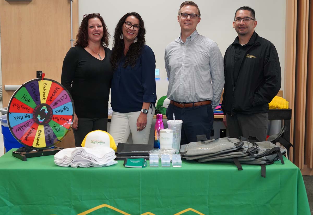Four deans standing at a booth