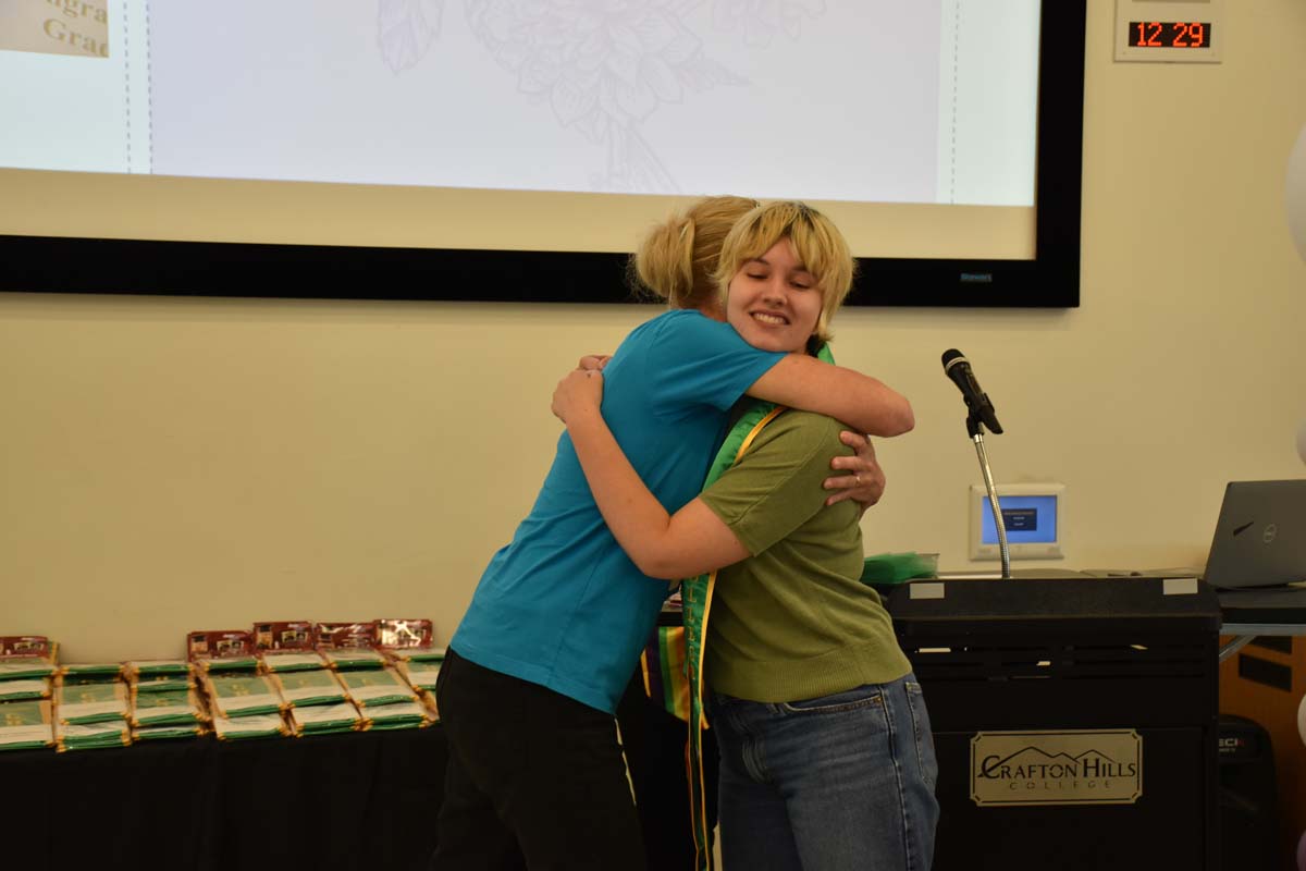 Student getting hugged while picked up sash