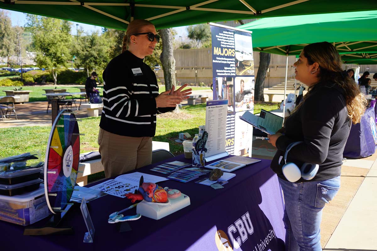 Student asking questions at a booth