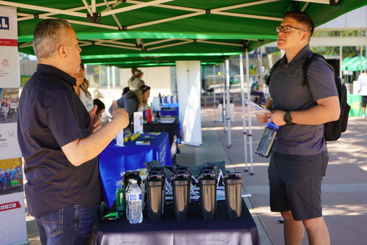 Student asking questions at a booth