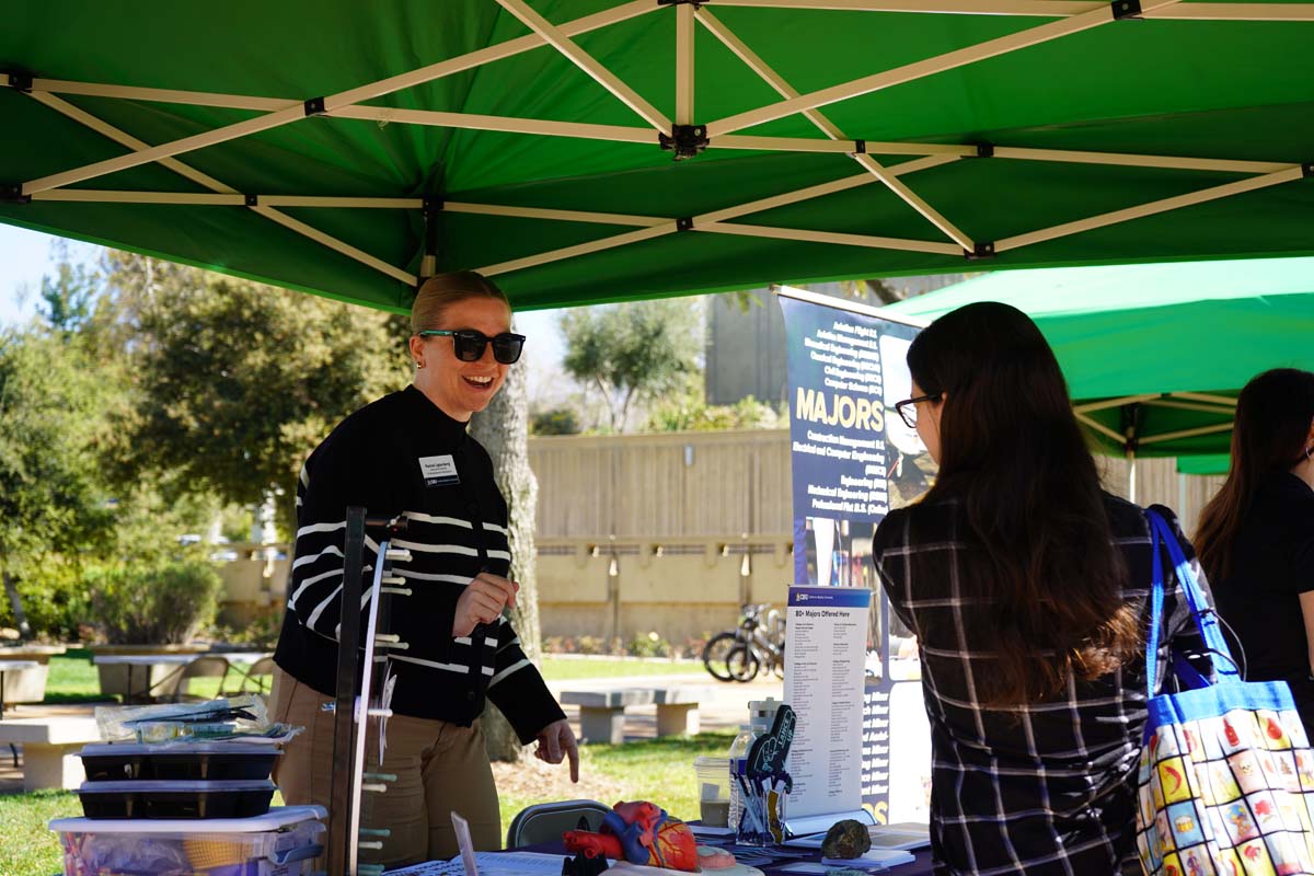Student asking questions at a booth