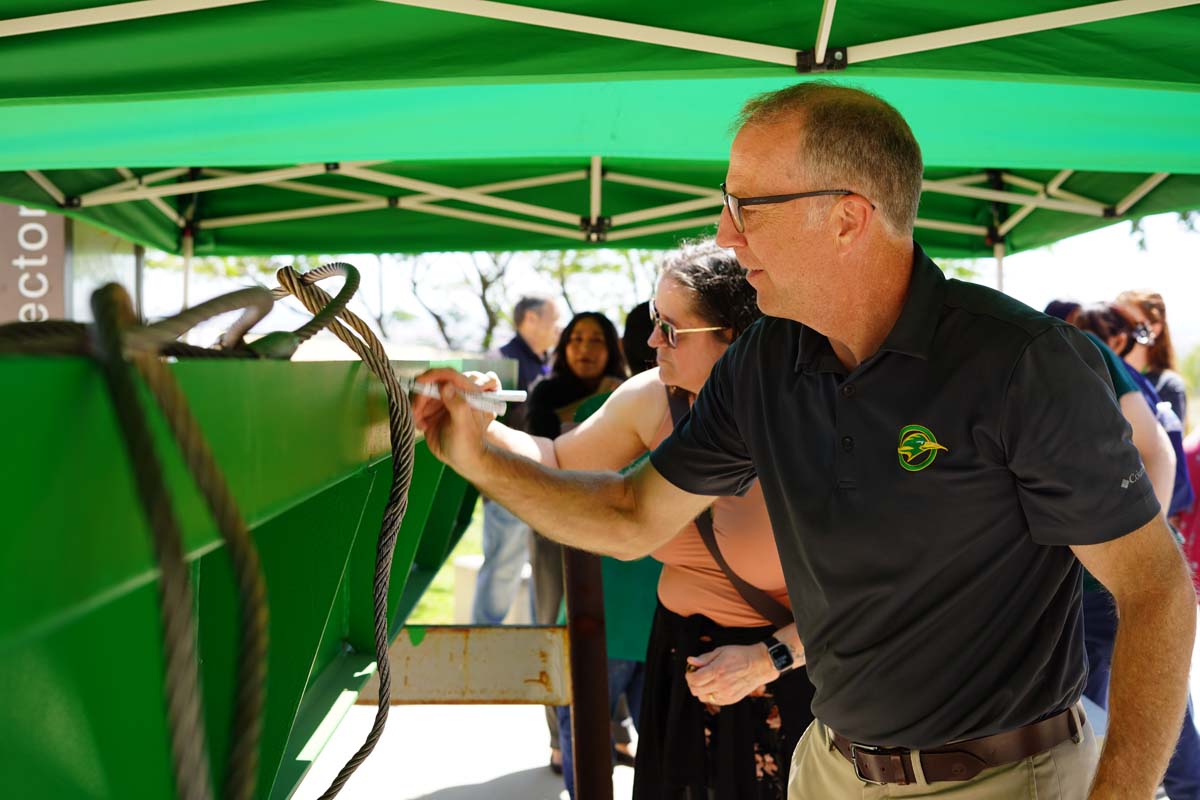 Mike Strong signing the beam
