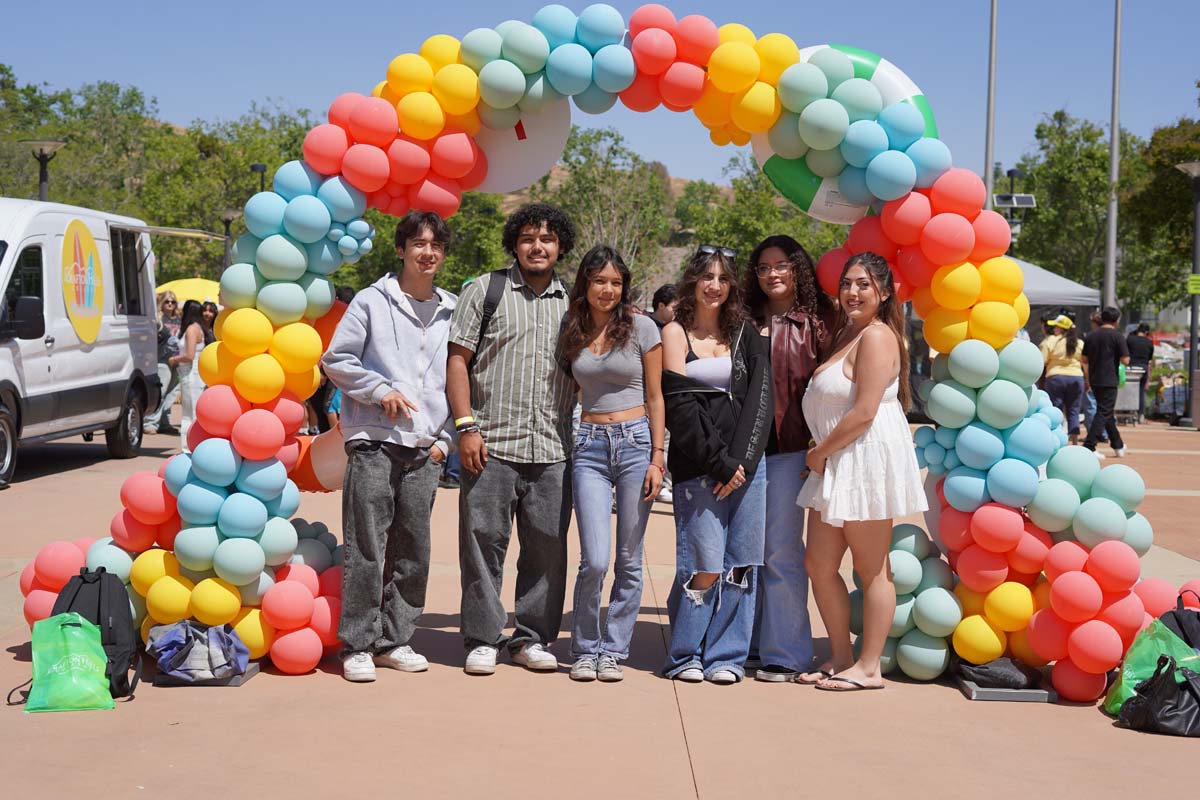 Senior day students in front of the balloon arch