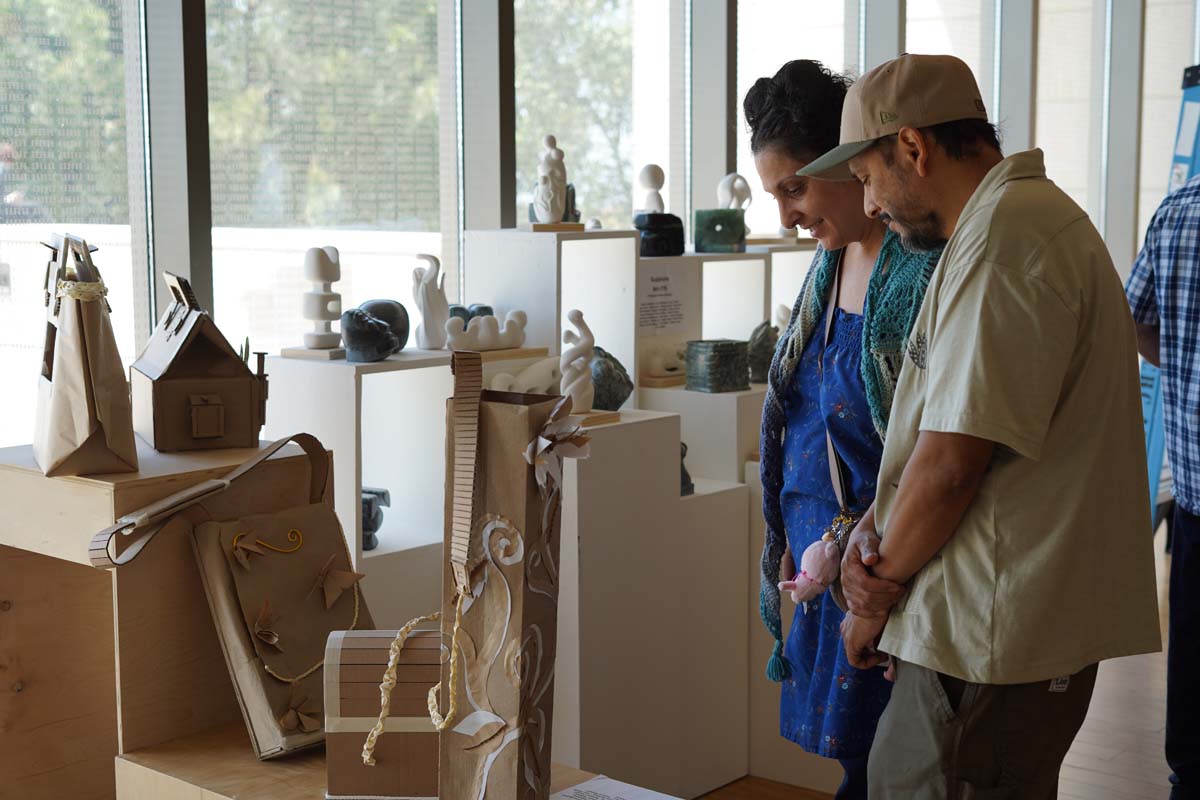 Two people looking at the sculptures