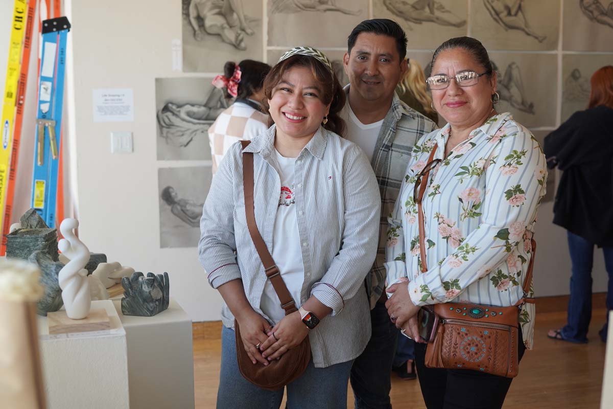 Student posing with their family at the exhibit