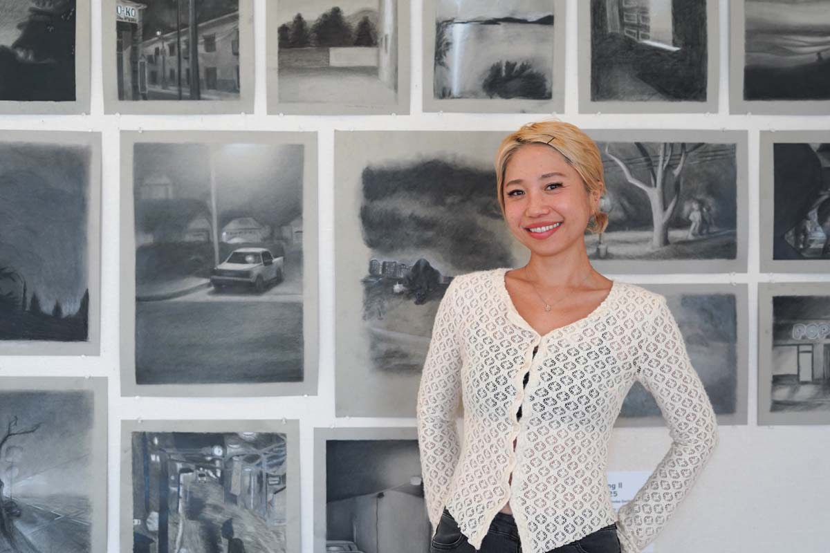 Student posing with her drawings