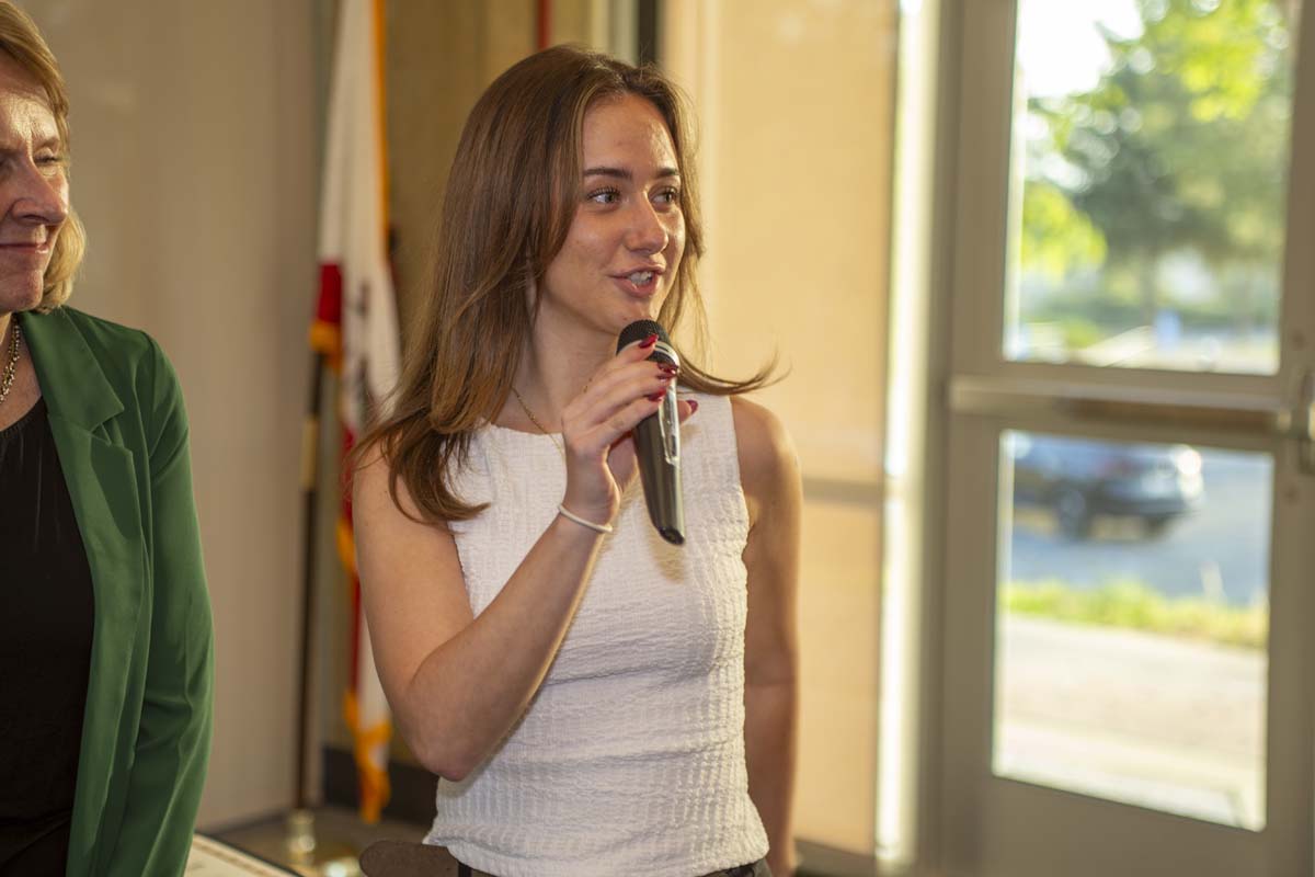 Student standing with a mic