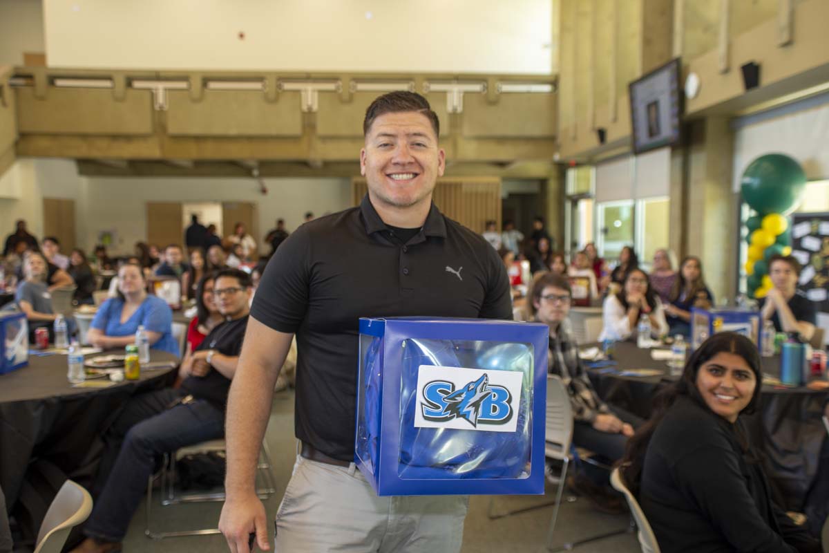 Student posing with CSUSB table decor