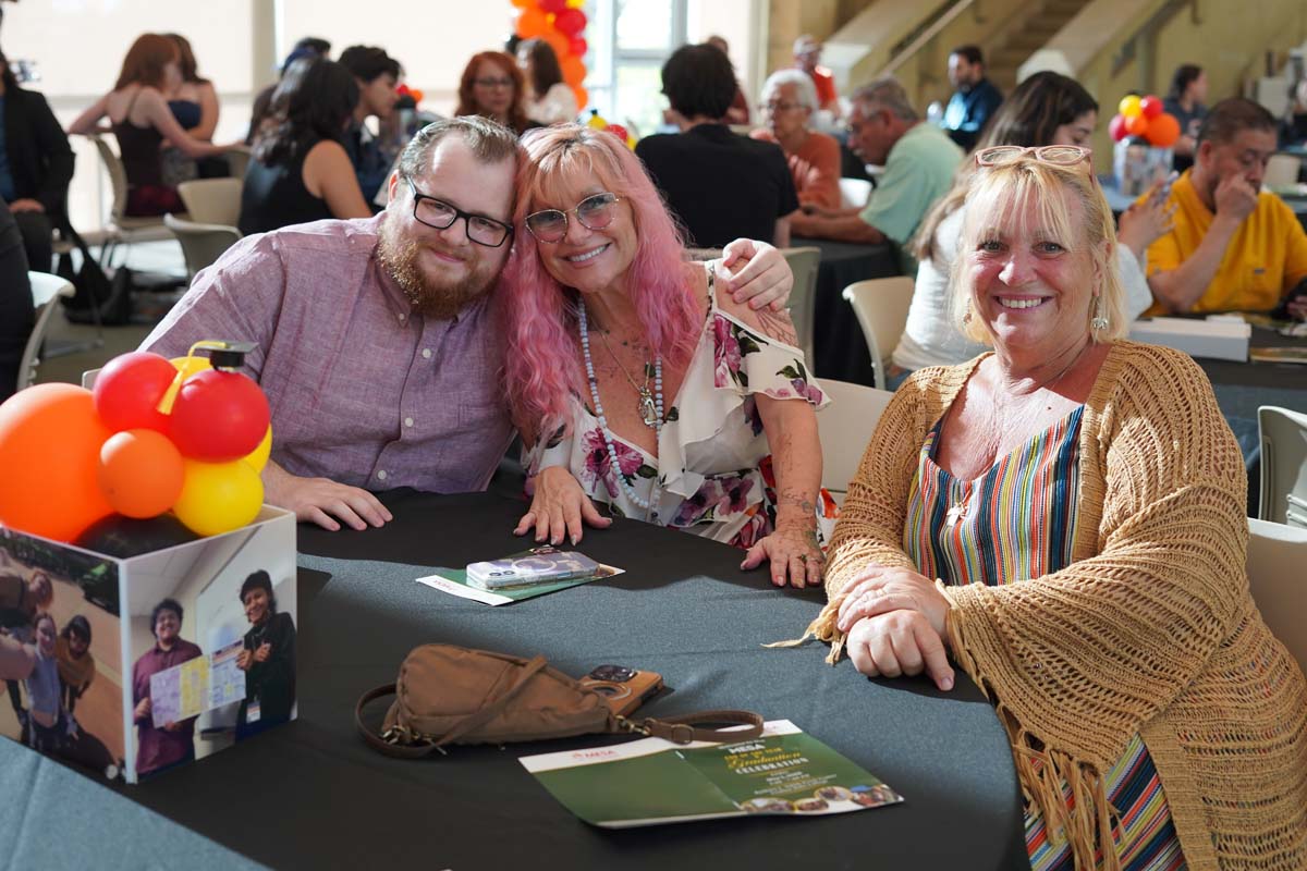 Three people smiling at a table