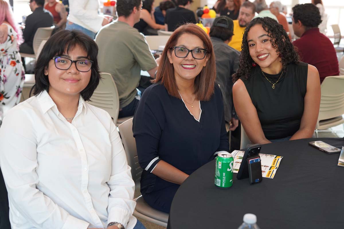 Three people smiling at a table