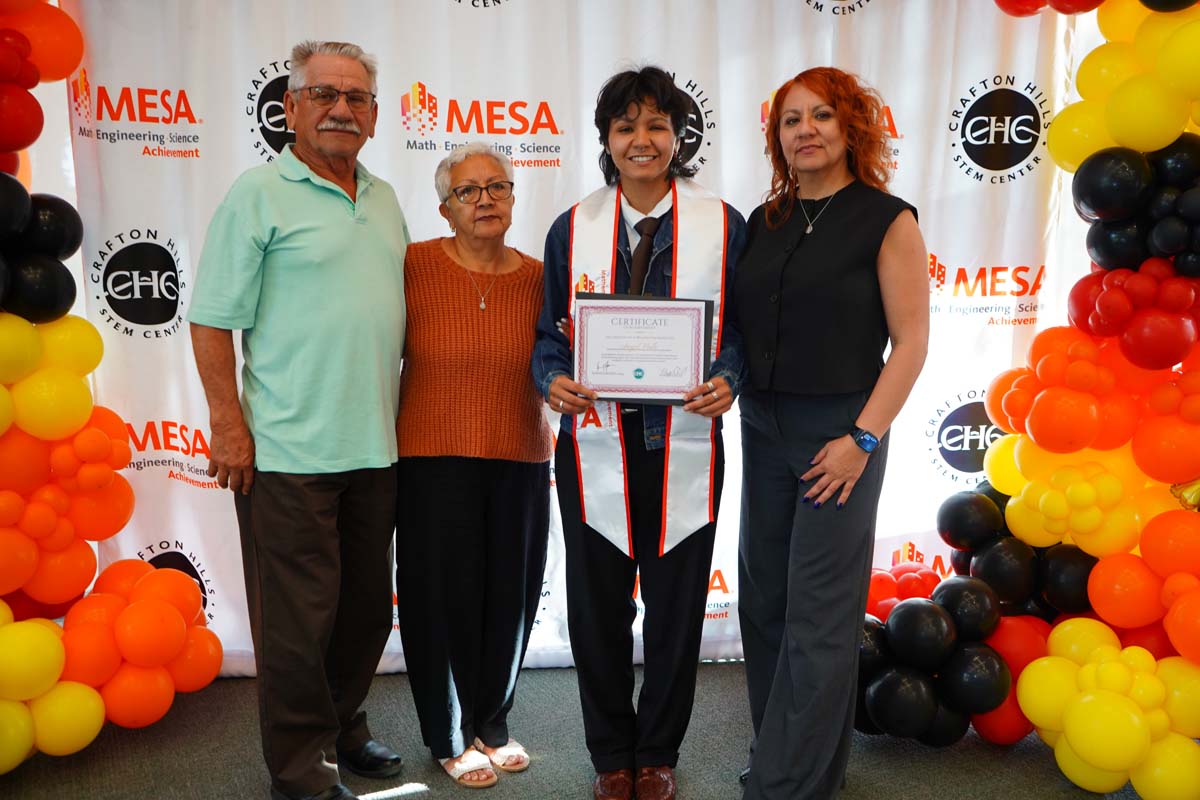 Student with their family in front of the backdrop
